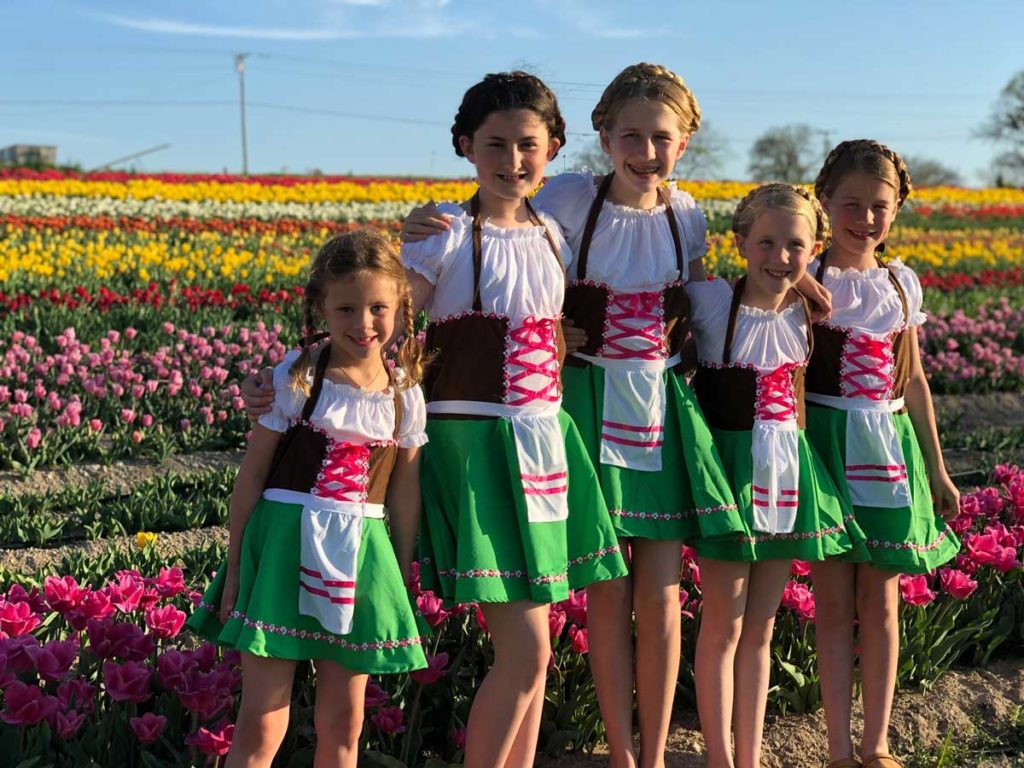 Photo of five girls in dutch dresses at Poston Gardens Tulipalooza in Waxahachie Texas