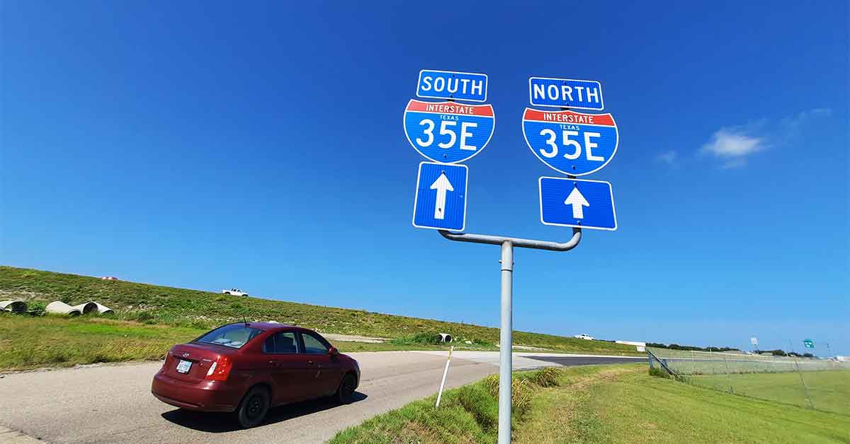 I-35 E. sign with red car driving by
