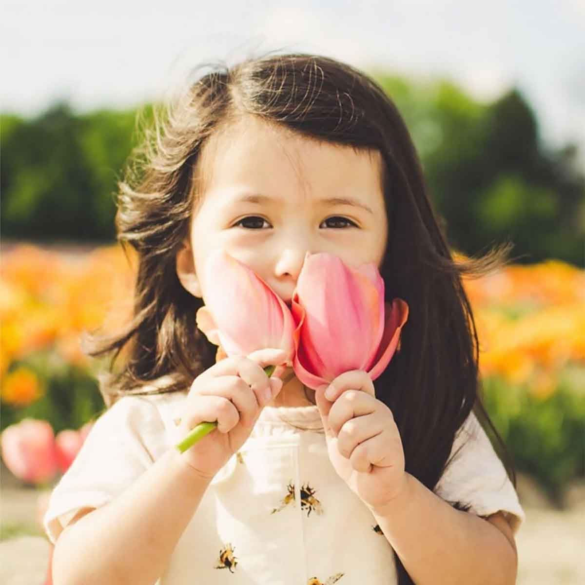 Girl smelling tulips at Poston Garden Tulipalooza event in Waxahachie Texas