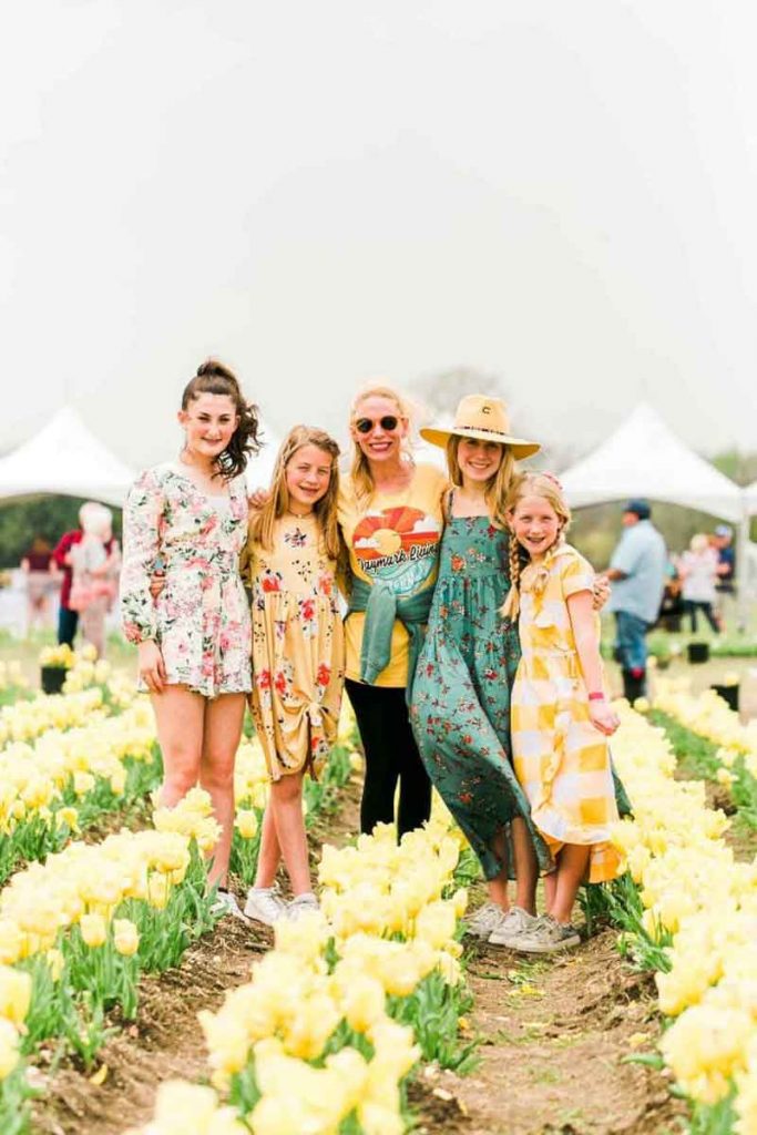 Woman with girls posing before tulips at Poston Garden Tulipalooza event in Waxahachie Texas