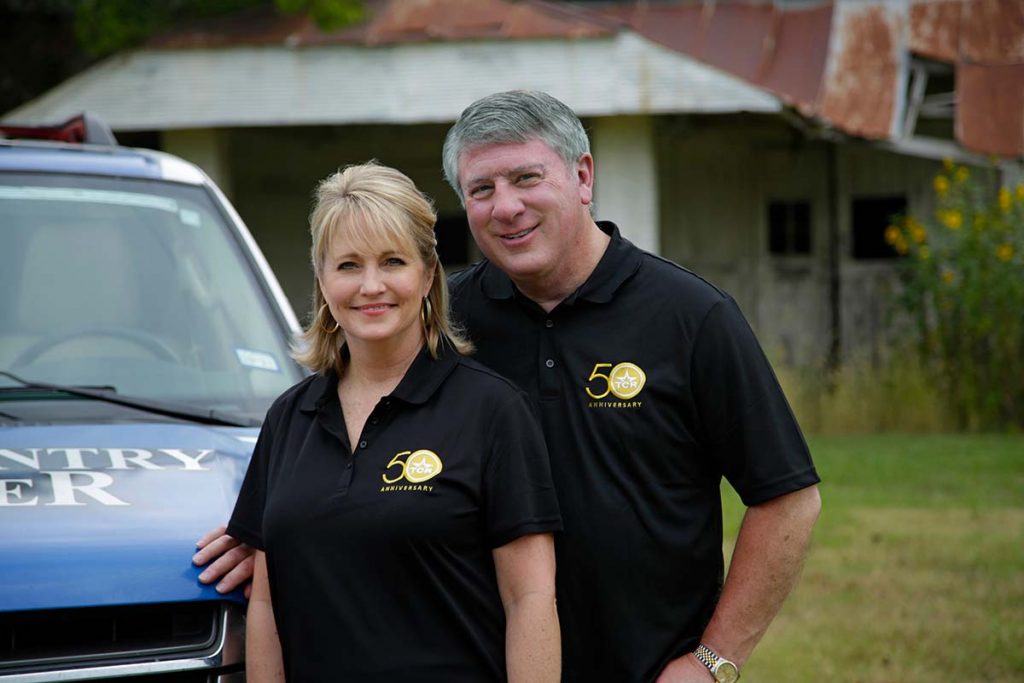 Kelli and Bob Phillips standing next to a turck