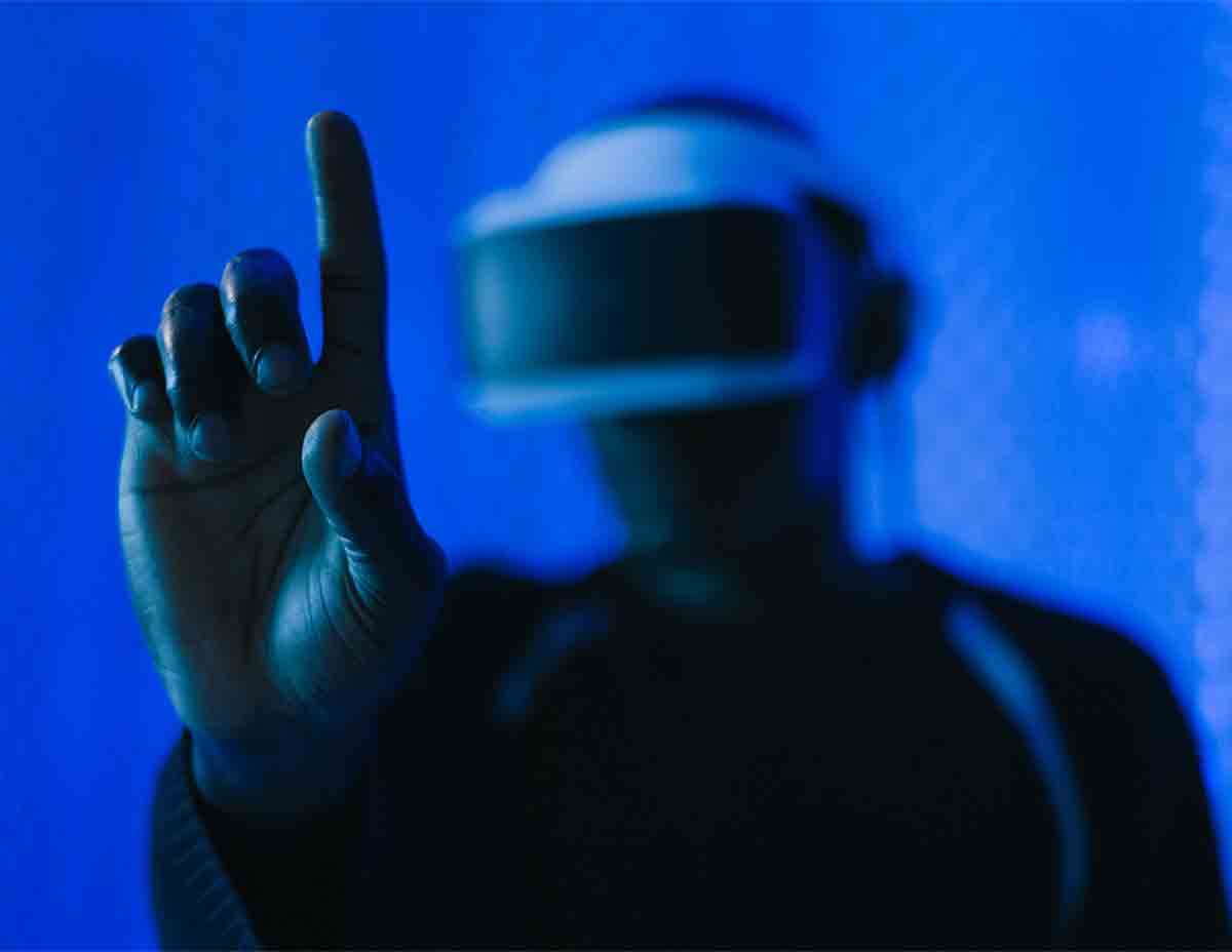 man with vr headset raising hand