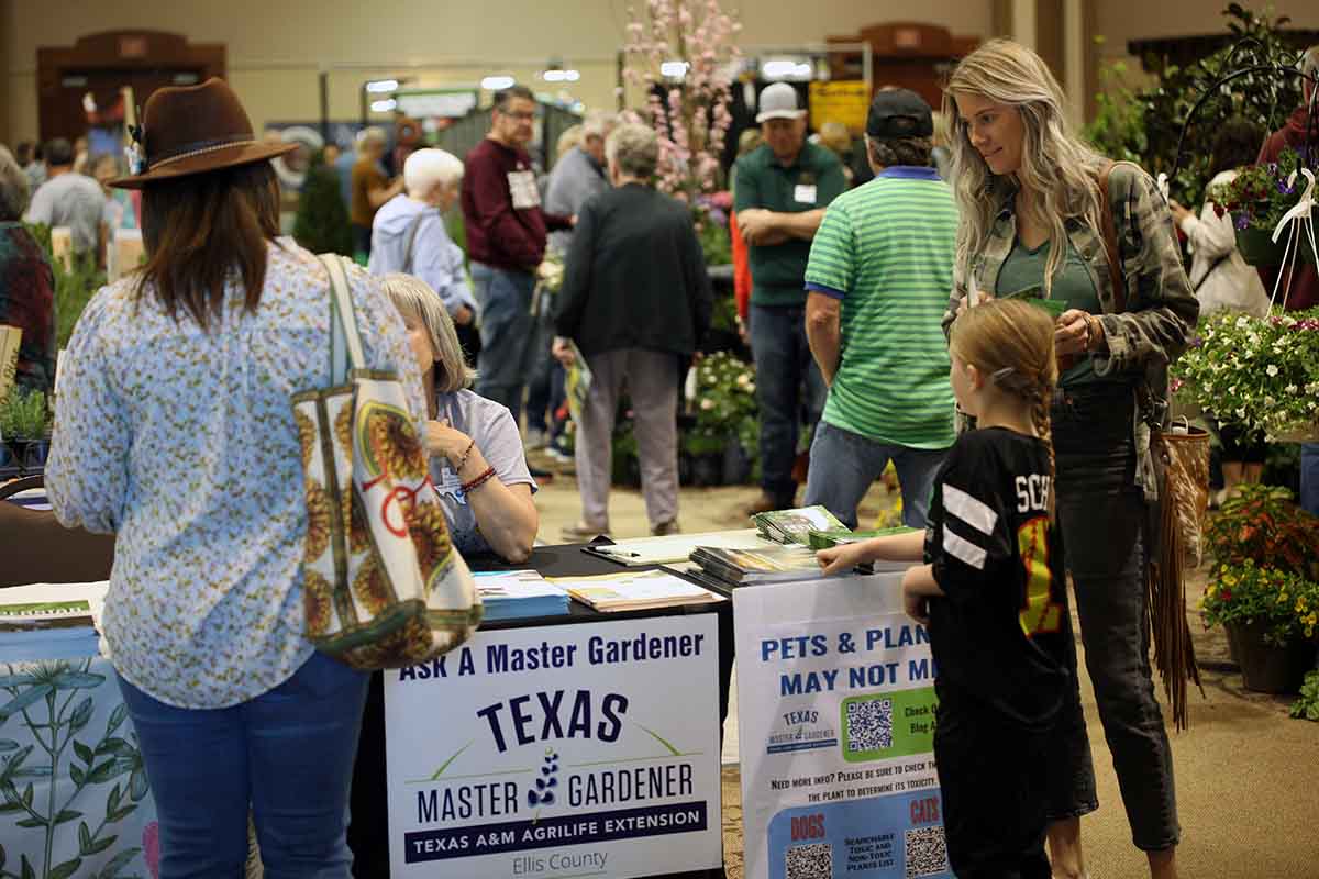 women and girl at Ellis County Master Gardeners table at Ellis County Lawn and Garden Expo