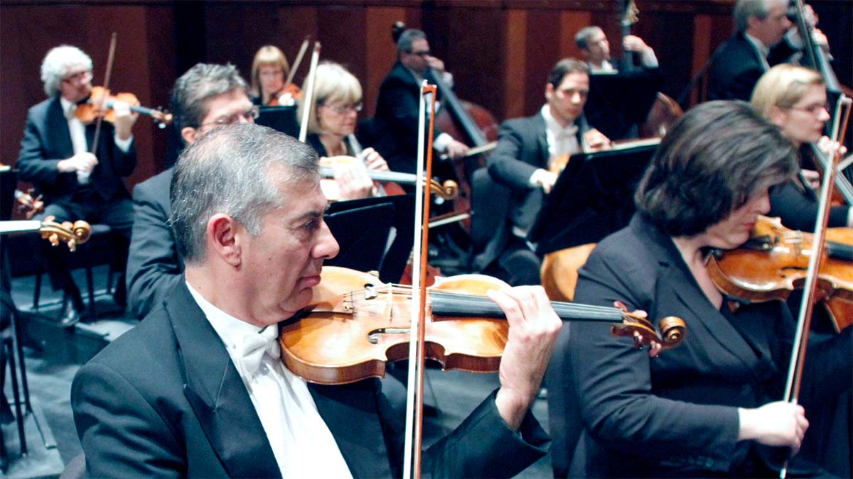 Musicians playing violin for the Fort Worth Symphony Orchestra